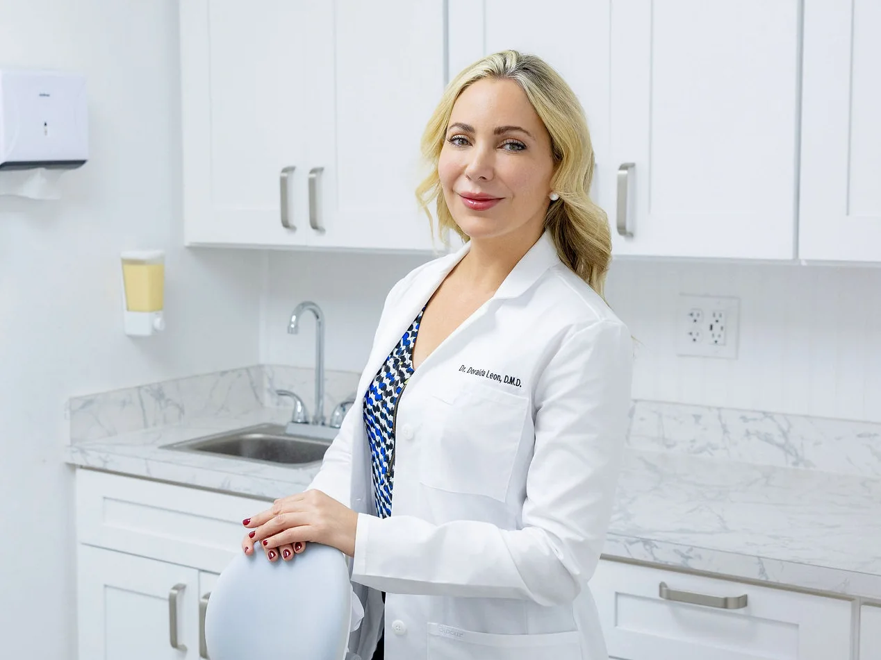 Dr. Leon in a treatment room, her hand on the chair